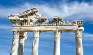 Ruines d'un temple grec, vestiges d'un dieu des arts grec, sous un ciel bleu et nuageux.