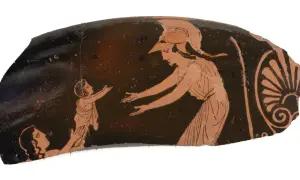 Fragment de poterie grecque montrant une femme casquée, peut-être Athéna, tendant les bras vers un enfant. Une autre figure est agenouillée. L'image évoque la protection maternelle, comme celle d'une mère pour ses fils d'Athéna.