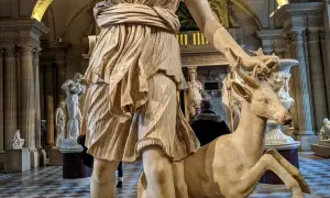 Statue d'Artémis caressant un cerf, un artémis animal emblématique de la déesse de la chasse, dans un musée.