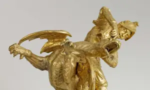 Statue dorée d'un guerrier combattant un dragon, évoquant le roi mythique d'Iolcos. Le guerrier, casqué, saisit la gueule ouverte de la créature ailée.
