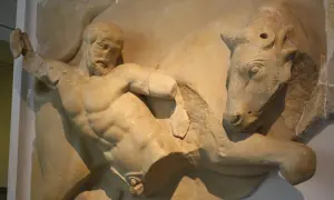Sculpture antique d'Hercule luttant contre un taureau. Le héros, musclé, saisit l'animal par les cornes.