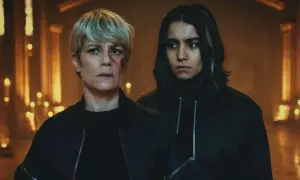 Deux femmes, l'une blessée, se tiennent dans une ambiance sombre, évoquant la furie de la mythologie.