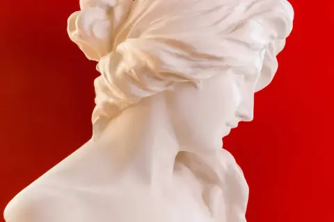 Buste en marbre blanc d'une femme aux cheveux tressés, évoquant la sérénité de Morphée, dieu des rêves.