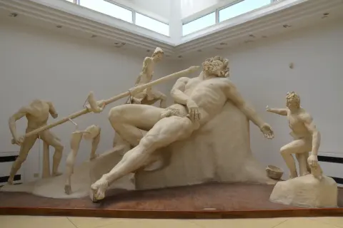Sculpture de Polyphème le cyclope, aveuglé par Ulysse. Des hommes tentent de le piquer à l'œil avec une lance.