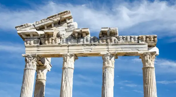 Ruines d'un temple grec, vestiges d'un dieu des arts grec, sous un ciel bleu et nuageux.