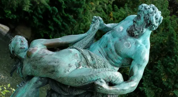 Sculpture de bronze patiné représentant un homme musclé, peut-être un attribut de Poséidon, luttant avec une femme.
