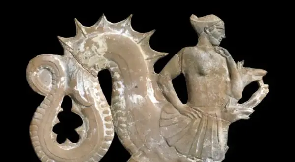 Figurine en terre cuite représentant un homme aux côtés d'une créature marine, évoquant la **charybde mythologie**.