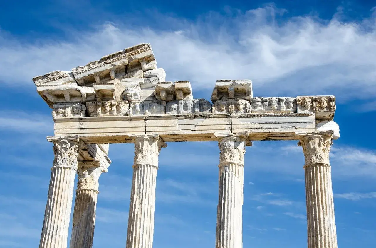 Ruines d'un temple grec, vestiges d'un dieu des arts grec, sous un ciel bleu et nuageux.