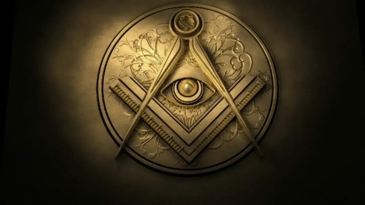 Symbole maçonnique doré en relief, avec une équerre, un compas et un œil, évoquant les mystères des grées.