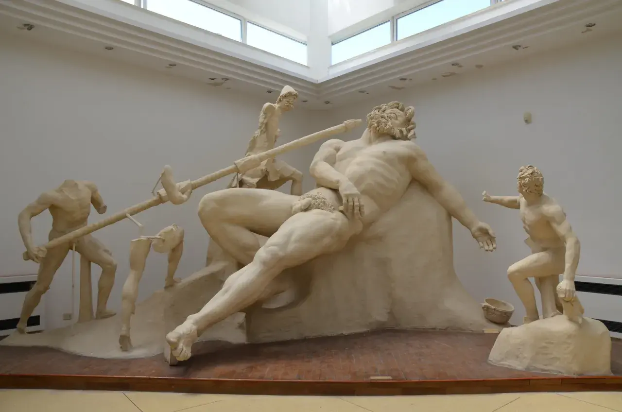 Sculpture de Polyphème le cyclope, aveuglé par Ulysse. Des hommes tentent de le piquer à l'œil avec une lance.