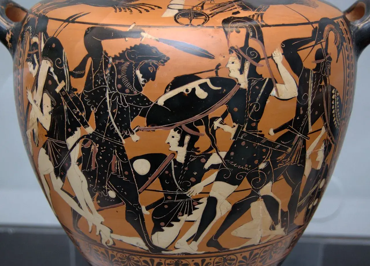 Vase antique représentant une scène de combat. Au centre, un guerrier barbu, peut-être Hippolyte, affronte un adversaire. La mythologie grecque prend vie.