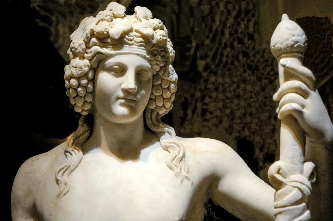 Sculpture de marbre d'une déesse du vin, coiffée de grappes de raisin, tenant un sceptre orné.