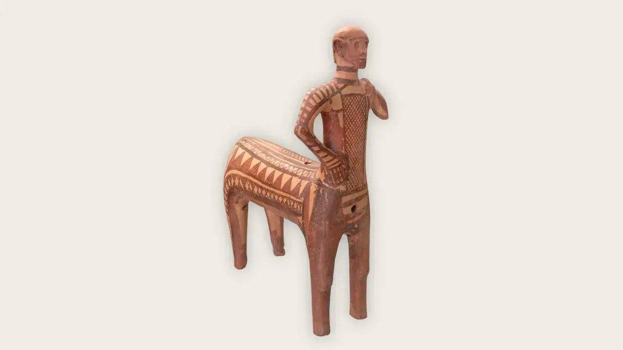 Figurine d'un mi homme mi cheval, en terre cuite, ornée de motifs géométriques et de bandes.