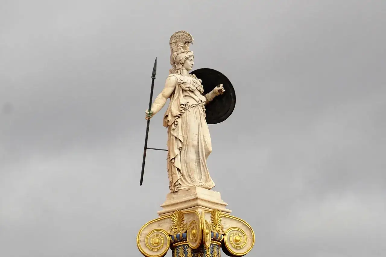Statue d'une d&eacute;esse de la guerre, casqu&eacute;e, tenant une lance et un bouclier, sur un chapiteau orn&eacute;.