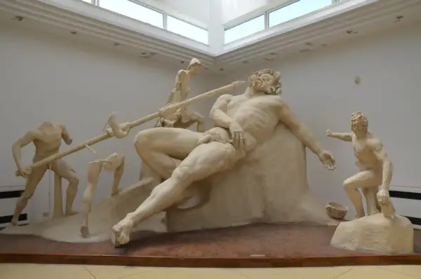 Sculpture de Polyphème le cyclope, aveuglé par Ulysse. Des hommes tentent de le piquer à l'œil avec une lance.