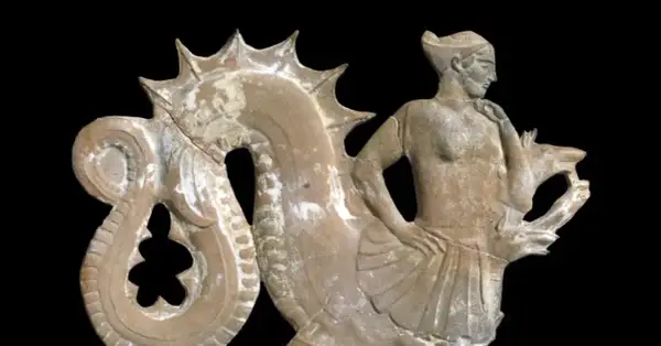Figurine en terre cuite représentant un homme aux côtés d'une créature marine, évoquant la **charybde mythologie**.