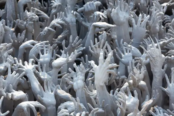 Des mains grises émergent du sol, une marée de désespoir rappelant le bident d'Hadès.