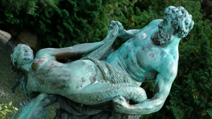 Sculpture de bronze patiné représentant un homme musclé, peut-être un attribut de Poséidon, luttant avec une femme.